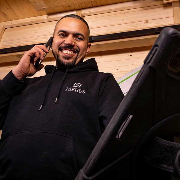 Yassir telefoniert und schaut auf Tablet